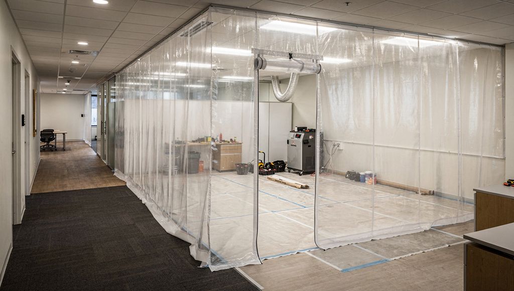 Dust-control screening and extraction within an occupied-building fit-out area.