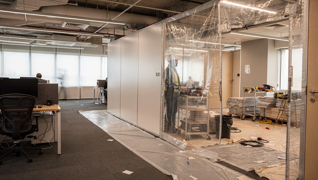 Segregated commercial fit-out work zone within an occupied office building.